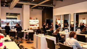 Salon modern de înfrumusețare plin cu clienți și stiliști